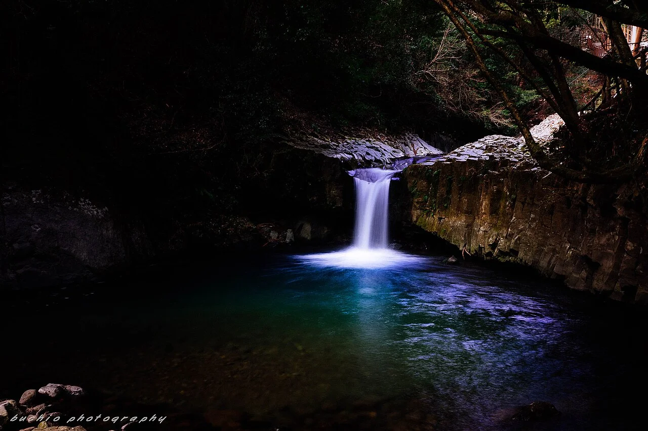 Hebidaru waterfall dropping between dark rock walls into a turquoise pool