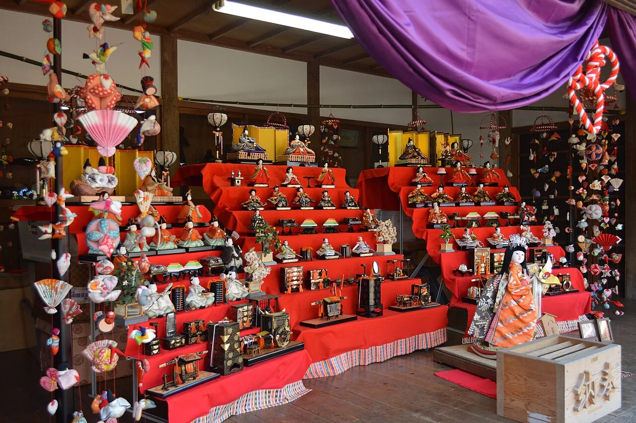 Hanging fabric decorations and red tiers of hina dolls at Inatori Hachiman Shrine