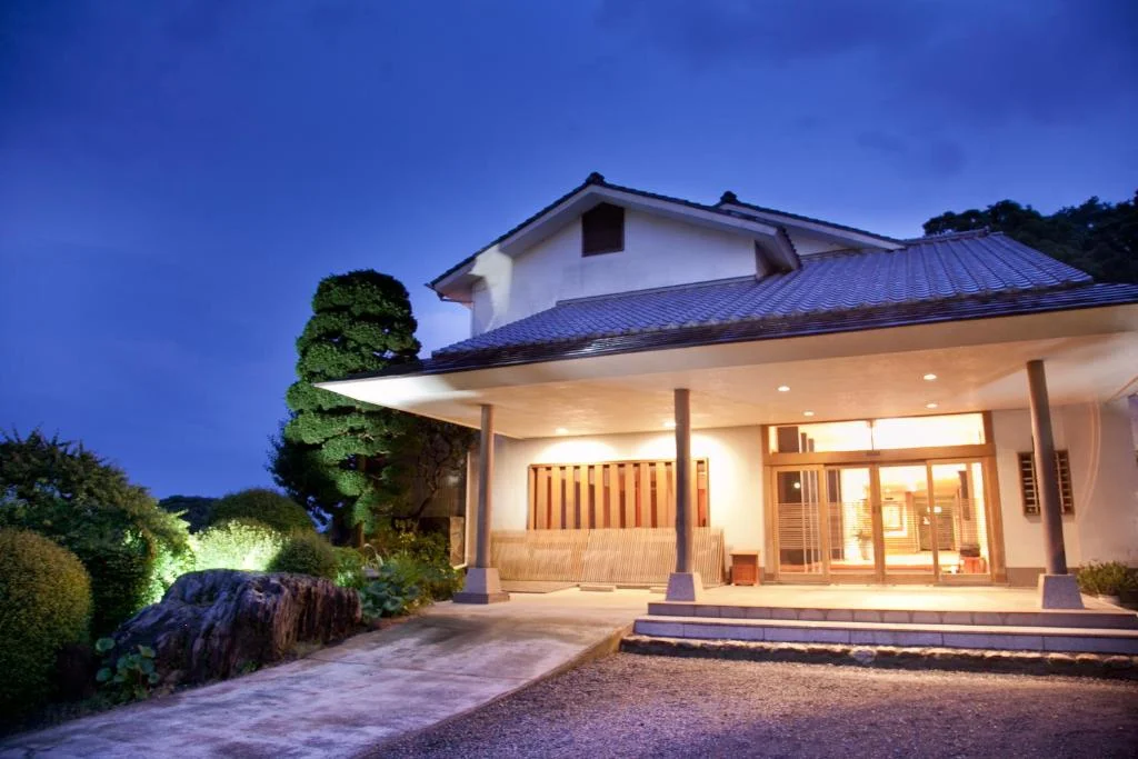 Illuminated entrance and driveway at Isaribi in the evening